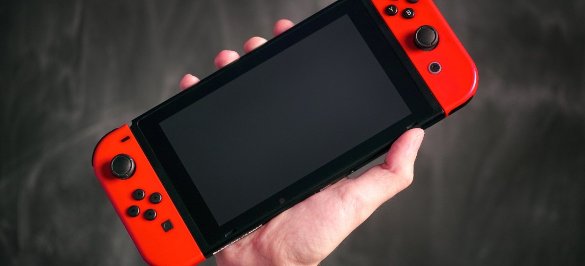 Eine Hand hält die Nintendo Switch in die Luft