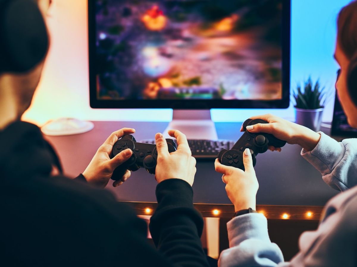 Paar sitzt vor einem Fernseher und spielt ein Videospiel